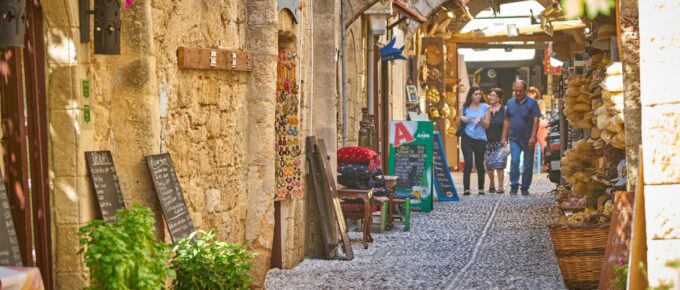 Tourists walking at the cobblestone street of old Rhodes town, Greece.