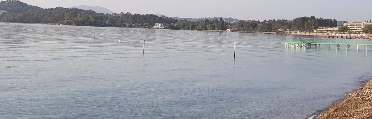 Calm Quiet Ionian Sea in the morning in Dassia, Corfu, Greece. Beautiful, warm, and perfect swimming water.
