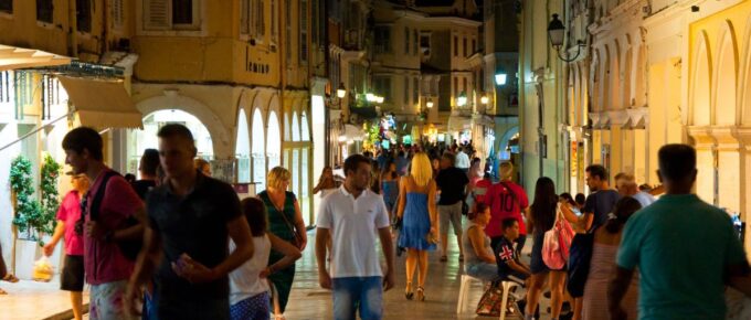 Tourists walk at night in Corfu island, Greece.