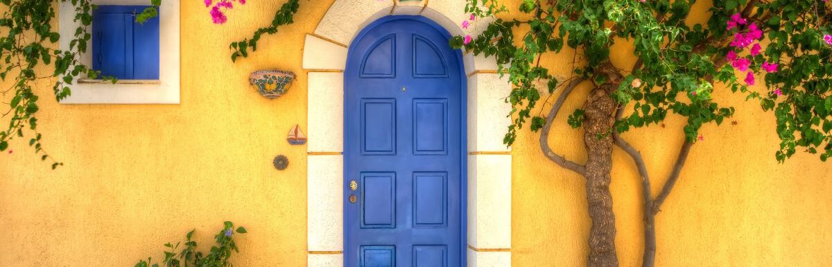 Yellow house with Blue Door in the village of Asos, Kefalonia, Greece.