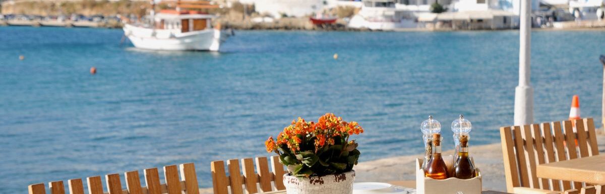 Dining table at restaurant by the water front at Mykonos, Greece, on a sunny day.