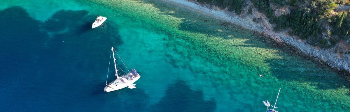 Aerial drone top down photo of sail boats anchored in small port of Frikes in Ithaca island, Ionian, Greece.