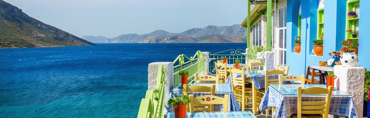 Greek restaurant on the balcony blue building overlooking the sea in Corfu, Greece.