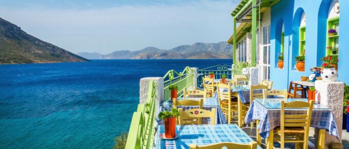 Greek restaurant on the balcony blue building overlooking the sea in Corfu, Greece.
