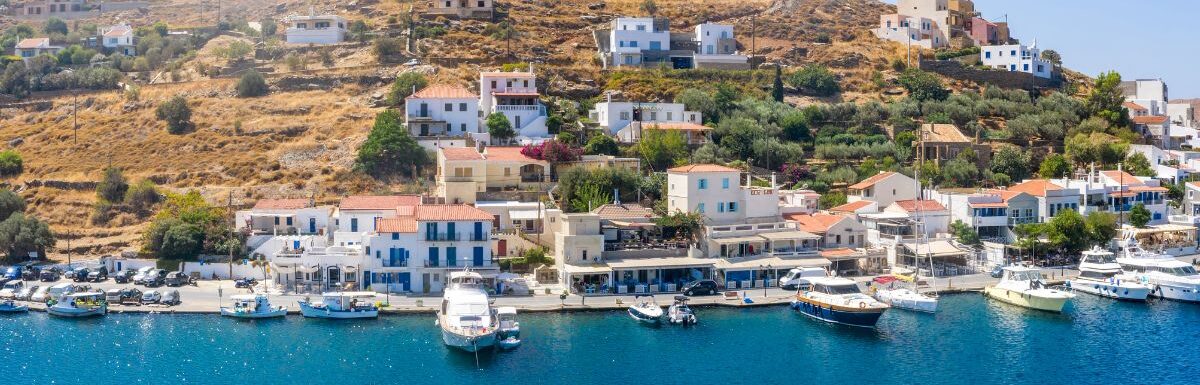 The small village of Vourkari on the island of Tzia, Kea, Greece, with moored yachts and sailboats in the Marina.