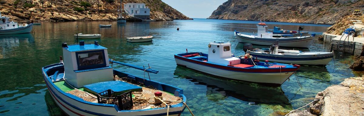 Traditional fishing boat floating on aegean sea in Sifnos in Greece by a nice summer day.