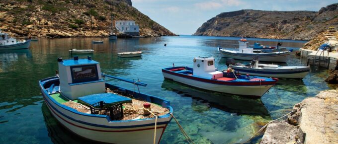 Traditional fishing boat floating on aegean sea in Sifnos in Greece by a nice summer day.