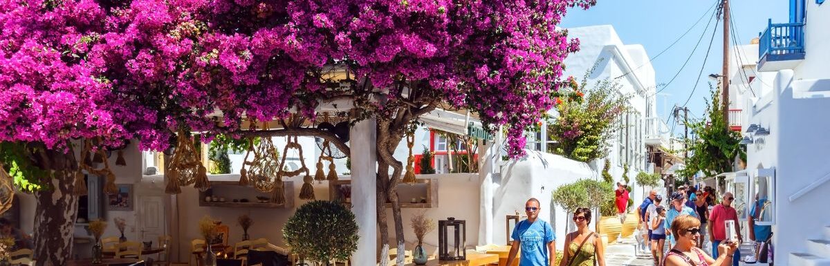 Shops and bars by street at the famous tourist spot of downtown on island Mykonos, Greece on June 2015.