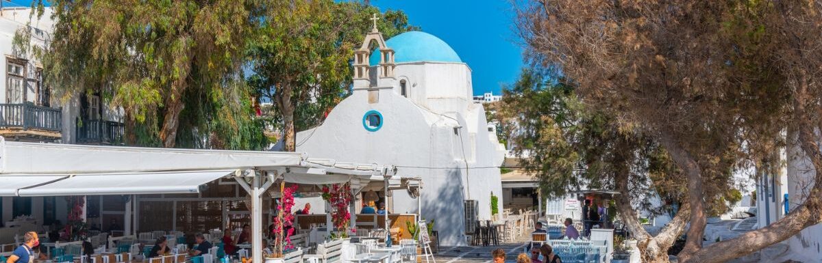 People eating at a restaurant at the old town of Mykonos, Greece.