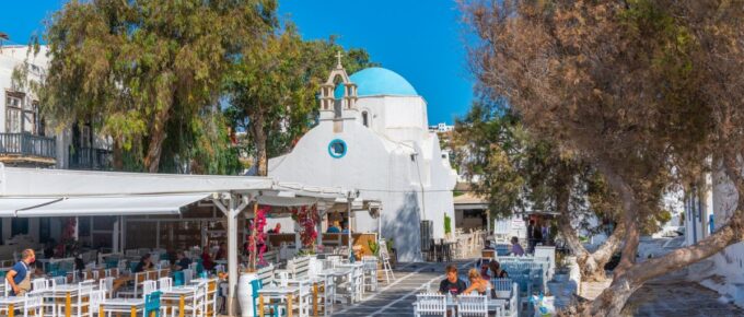 People eating at a restaurant at the old town of Mykonos, Greece.