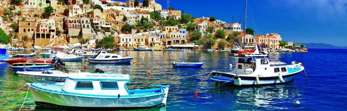 Symi island, Dodecanes, Greece, with boats and houses in the background on a sunny day.