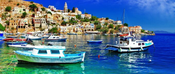 Symi island, Dodecanes, Greece, with boats and houses in the background on a sunny day.