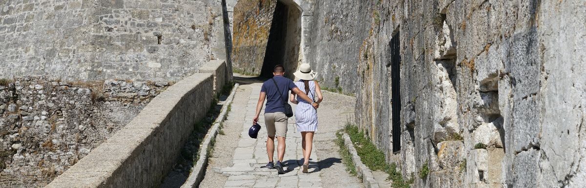 Young couple walking at the Old Fortress of Corfu Town, Old Town of Corfu, Greece.