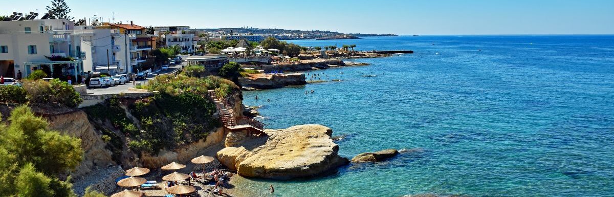 Many people enjoy a summer day at the beach of Hersonissos on the island of Crete in Greece.