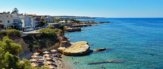 Many people enjoy a summer day at the beach of Hersonissos on the island of Crete in Greece.