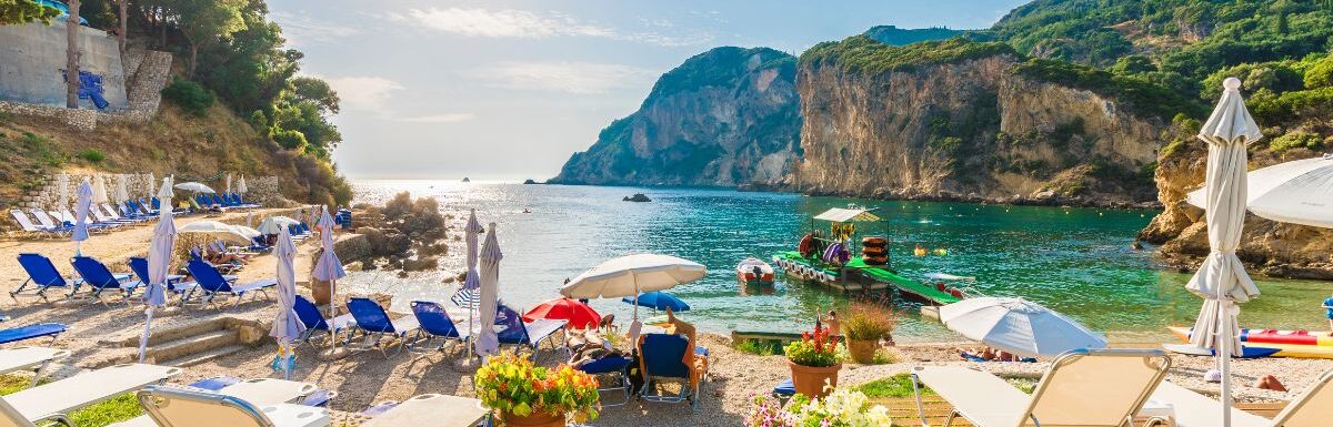 Sunbeds and umbrella on the beach in Corfu Island, Greece.