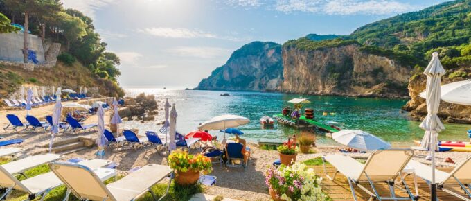 Sunbeds and umbrella on the beach in Corfu Island, Greece.