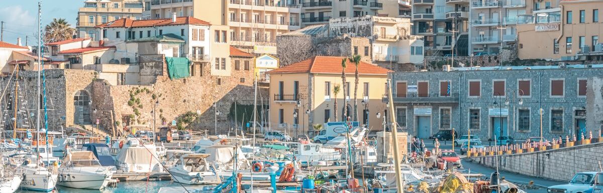 Boats and yachts in the port on the background of Heraklion city, Crete, Greece.