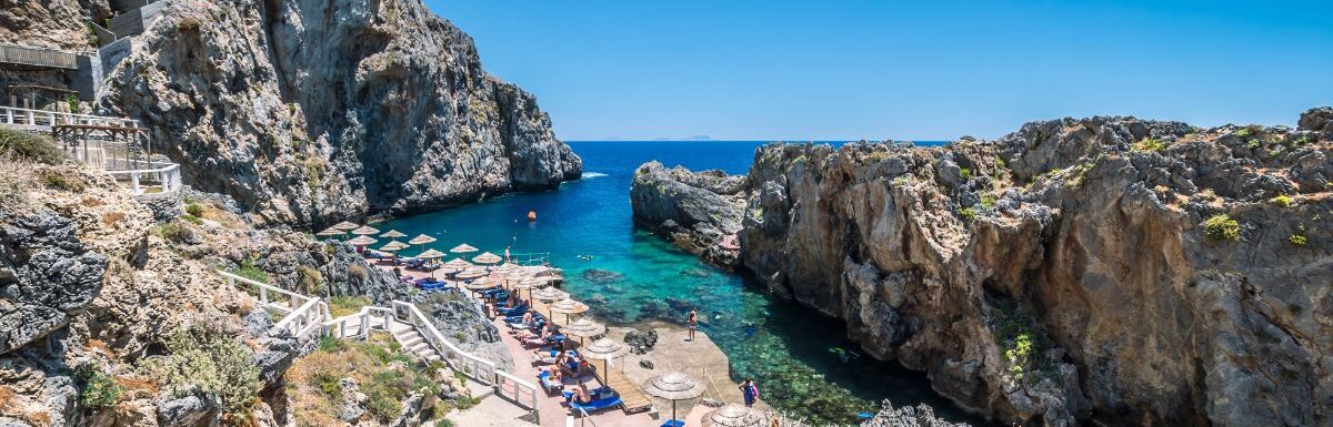 Tourists relax and bath in crystal clear water of Kalypso, Karavos beach in Crete Island, Greece.