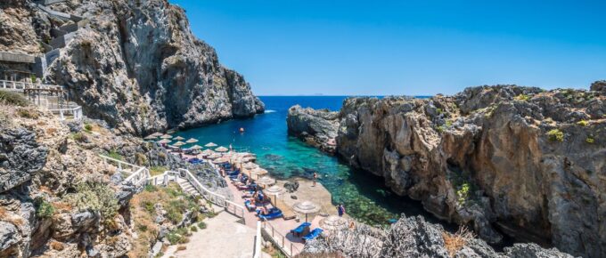 Tourists relax and bath in crystal clear water of Kalypso, Karavos beach in Crete Island, Greece.