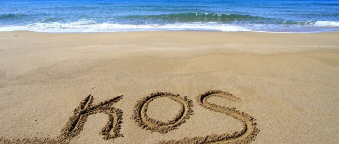 Kos word written on sandy beach.