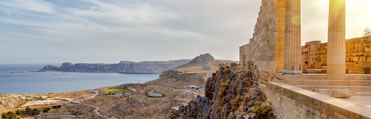 Doric columns of the ancient Temple of Athena Lindia setting sun above the columns in the Acropolis of Lindos, Rhodes, Greece.